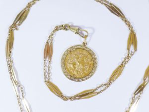 Lotto 118915 - Catena in oro giallo e ciondolo in oro giallo raffigurante San Giorgio a cavallo che uccide il drago